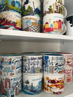 many coffee mugs are stacked on the shelf