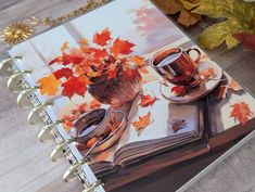 an open book with coffee cups and autumn leaves