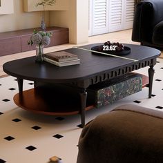 a living room with black couches and a coffee table in the middle of it