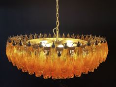 a chandelier made out of wine glasses hanging from a chain