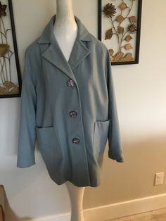 "This jacket is a paler blue done in a light weight wool...it is fully lined in a crepe like fabric. Big buttons down the front. Could wear dressed up or down. Just back from drycleaner. There are no labels in piece so please check measurements carefully. Jacket measurements: 48\" bust; 48\" mid body; 31\" tall; 47\" hemline; 9 1/2\" sleeve hem; buttons are 1 1/4\" around. Few issues to note: one small pin prick on back near shoulder; one small stain on front, near hemline, please see picture. T Blue Wool Coat With Lapel Collar And Pockets, Blue Collared Outerwear With Buttoned Pockets, Blue Button-up Sport Coat With Buttons, Blue Wool Coat With Button Closure And Lapel Collar, Blue Wool Blazer With Button Cuffs, Blue Wool Outerwear With Pockets, Blue Wool Coat With Pockets For Work, Blue Outerwear With Buttoned Pockets For Work, Blue Sport Coat With Buttons