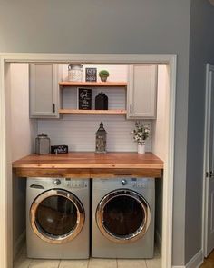 a washer and dryer in a small room with open shelves above the doors