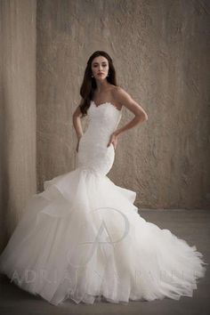 a woman in a white wedding dress posing for the camera with her hands on her hips