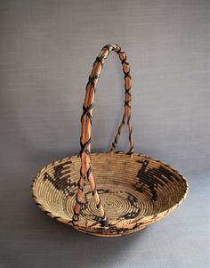 an old woven basket is sitting on the floor with two handles and braided ends