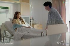 a man standing next to a woman in a hospital bed