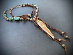 "Gorgeous hand carved fang from Tibet on a necklace of earthy jasper, turquoise and jade. Finished off with vintage chain and soft leather at the back and tied around the focal. Sliding beads in back let you adjust the length up to 5\". Measures 32\" total. Focal measures 6\"." Adjustable Beaded Rustic Turquoise Necklace, Adjustable One-of-a-kind Turquoise Necklace For Festivals, Adjustable Brown Turquoise Bohemian Necklace, Handmade Rustic Adjustable Turquoise Necklace, Handmade Adjustable Brown Turquoise Necklace, Bohemian Adjustable Patina Necklace, Fang Necklace, Vintage Chain, Leather Jewelry