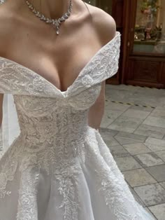 a woman in a wedding dress is posing for the camera with her hand on her hip