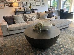 a living room filled with lots of furniture and pictures on the wall above it's coffee table