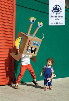 two children are walking past a cardboard box