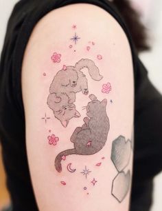 a woman's arm with an image of two cats and a mouse on it