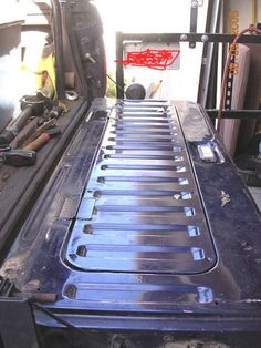 the back end of a truck that is being worked on with tools and other items