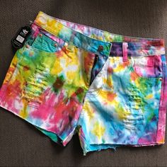 a pair of shorts with colorful tie dye on the front and back, sitting on a couch