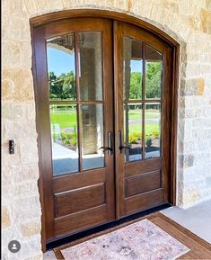 the front door to a home with two double doors and a rug on the floor