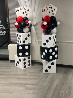 some black and white polka dot balloons are on top of each other in front of a window