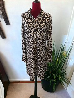 This is a beautiful International Concepts dress. It is Black with white circulars. It has seven gold buttons in front, a turn down collar, long sleeves with two gold buttons on the end of each. This is a lovely knee length dress made of 95% polyester and 5% spandex. The dress is a size XLarge and has a stretch to it. Bust: 42” (has stretch) Waist: 38” (has stretch) Sleeves: 25” Dress Length: 38” Fall Long Sleeve Midi Dress With Covered Buttons, Casual Long Sleeve Gold Dress, Casual Gold Long Sleeve Dress, Gold Long Sleeve Dress For Work, Gold Long-sleeved Dress For Work, Long Sleeve Gold Dress For Work, Gold Buttons, Knee Length Dress, Dress Making