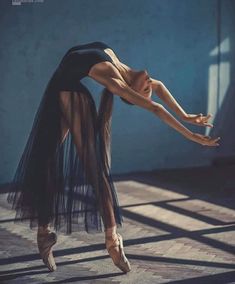 a ballerina is posing for the camera with her arms stretched out and legs bent