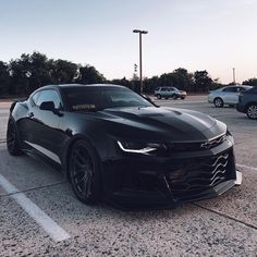 a black chevrolet camaro parked in a parking lot