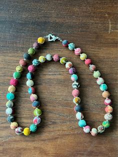 a multicolored beaded necklace on a wooden table