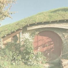 an old hobbot house with grass on the roof