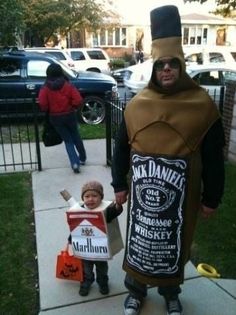 a man in a costume is holding a child's hand and walking down the sidewalk