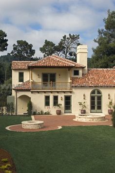 a large house in the middle of a lush green field