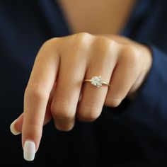 a woman's hand with a diamond ring on her finger, showing the middle finger