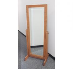 a large wooden mirror sitting on top of a floor