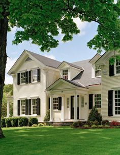 a large white house with black shutters and windows