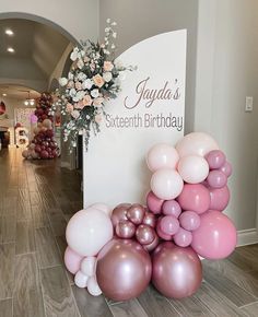 balloons are stacked on top of each other in front of a sign that reads jaganda's sixteenth birthday