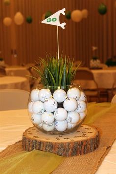 golf balls in a glass vase on top of a table