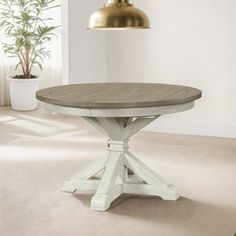 a white table sitting in front of a potted plant