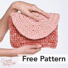 a hand holding a crocheted pink and red purse over it's shoulder