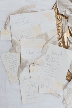 the wedding stationery is laid out on top of each other, with gold foil