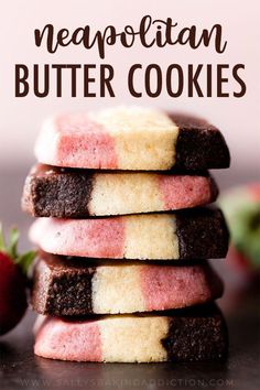 a stack of cookies with pink and white frosting on top, next to strawberries