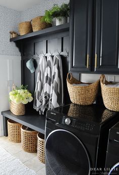 a washer and dryer in a laundry room with baskets on the shelf next to it