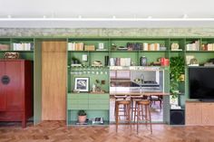 a living room filled with furniture and a flat screen tv on top of a wooden shelf