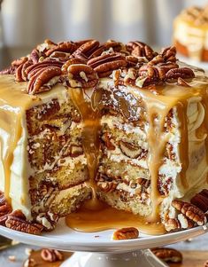 a cake with pecans and caramel drizzled on top is sitting on a plate