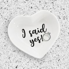 a white heart shaped dish with the words i said yes written in black on it