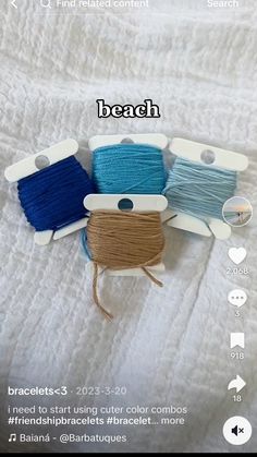 three spools of thread sitting on top of a white bed next to each other