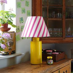 a yellow lamp sitting on top of a wooden table