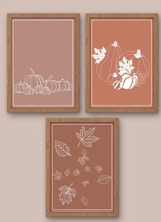 three framed pumpkins and leaves are on the wall in front of two brown frames