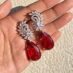 Red Diamond Earrings featuring semi precious red stones and cz diamonds. Ideal to pair with your designer outfits and bridal wedding gown. These PREMIUM QUALITY Red Earrings surely elevate your look. Perfect gift for her. *𝐏𝐑𝐎𝐃𝐔𝐂𝐓 𝐃𝐄𝐓𝐀𝐈𝐋* * 𝐌𝐚𝐭𝐞𝐫𝐢𝐚𝐥: Brass * 𝐏𝐥𝐚𝐭𝐢𝐧𝐠: White Rhodium Plated * 𝐒𝐭𝐨𝐧𝐞: AAA-quality CZ diamond. 𝐕𝐢𝐬𝐢𝐭 𝐎𝐮𝐫 𝐅𝐀𝐐𝐬 𝐟𝐨𝐫 𝐒𝐡𝐢𝐩𝐩𝐢𝐧𝐠 𝐏𝐨𝐥𝐢𝐜𝐢𝐞𝐬 𝐚𝐧𝐝 𝐂𝐚𝐫𝐞 𝐈𝐧𝐬𝐭𝐫𝐮𝐜𝐭𝐢𝐨𝐧 *𝐃𝐈𝐒𝐂𝐋𝐀𝐈𝐌𝐄𝐑* * Product color Luxury Ruby Earrings For Valentine's Day, Red Diamond Earrings, Wedding Earrings Bride, Earrings Bride, Red Stones, Bride Earrings, Designer Outfits, Red Diamond, Ruby Earrings