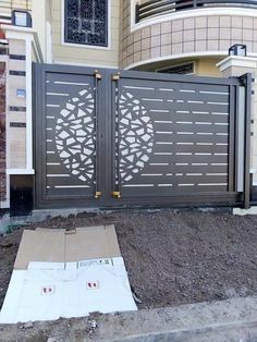 a large gate with an intricate design on it in front of a house that is under construction