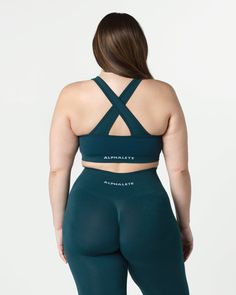 HIGHLIGHTS. Removable cups. Scrunch detailing in the center. Medium to high impact. Moisture-wicking, breathable fabric. V-shaped neckline and crossing back straps. Unbelievably soft texture. Proprietary seamless blend of fine Italian yarn. Alphalete core wordmark knitted in white. Reinforced binding arm and neckline finishing FIT SUGGESTION. This item has a compression fit.. If you are between sizes, we recommend sizing up.. Model is 5’11”/180.3cm, wearing a size L with a 42.5”/108cm bust.. MAT Fitted Top With Seamless Construction And Cross Back, Compressive Seamless Activewear Bra Friendly, Medium Support Seamless Cross Back Sports Bra, Medium Support Seamless Sports Bra With Cross Back, Medium Support Seamless Cross-back Sports Bra, Seamless Cross Back Yoga Activewear, Yoga Activewear With Seamless Cross Back, Yoga Seamless Cross Back Activewear, Seamless Medium Support Sports Bra With Cross Back