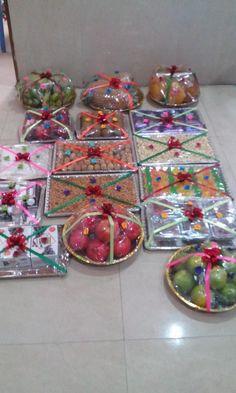 many different types of food wrapped in plastic and tied with ribbons on the floor next to each other