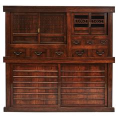 an old wooden cabinet with many drawers and doors on the front, in dark wood