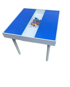 a table with legos on it and some colored beads in the middle of it