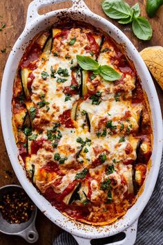 a casserole dish with zucchini, cheese and sauce