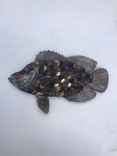 a fish made out of bottle caps on a white surface