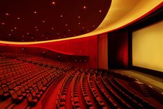 an empty auditorium with rows of seats and a projector screen